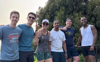 A group of Metropolis engineers pose for a photo outside together in athletic wear.