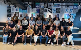 A group of Qualtrics employees gather together for a group photo.