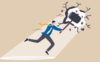 Illustration of a businessman swinging a large hammer as he creates a hole in a wall, symbolizing breaking into a new career.