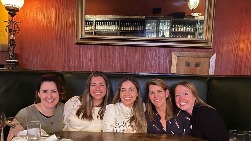 A group of Qualtrics employees pose for a group photo 